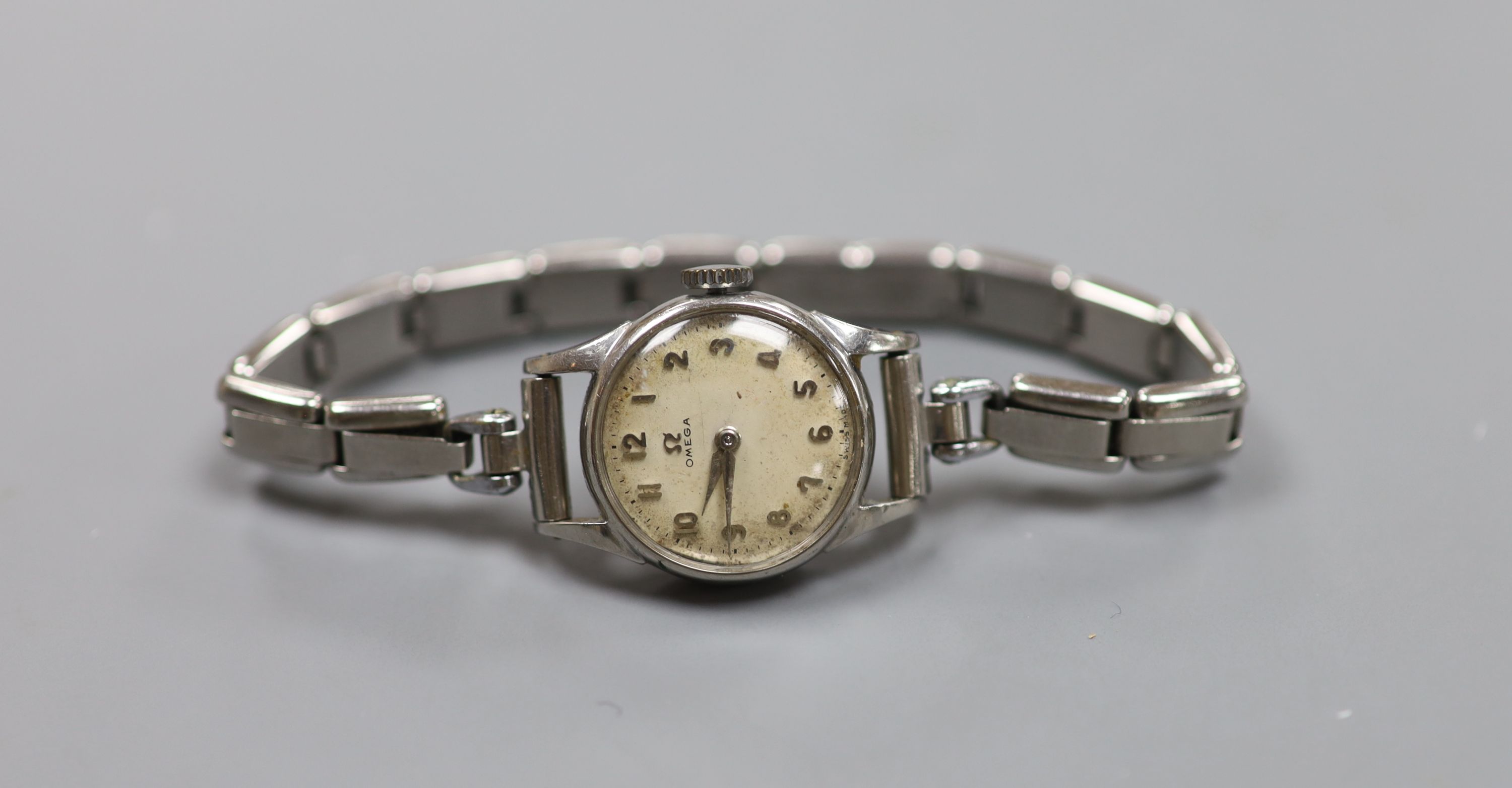 A lady's stainless steel Omega manual wind wrist watch, on associated flexible bracelet.